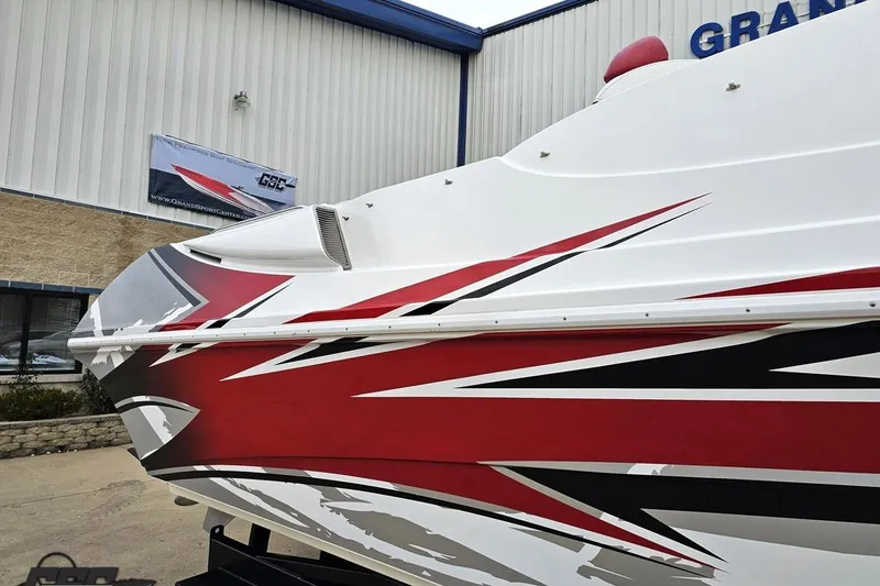 Slide: The Image of 2004 Black Thunder 460 boat with dynamic red and black graphics, displayed at dealership. - 6