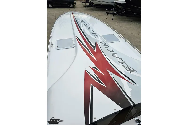 Slide: The Image of 2004 Black Thunder 460 boat with bold graphics on deck, docked in a marina. - 64