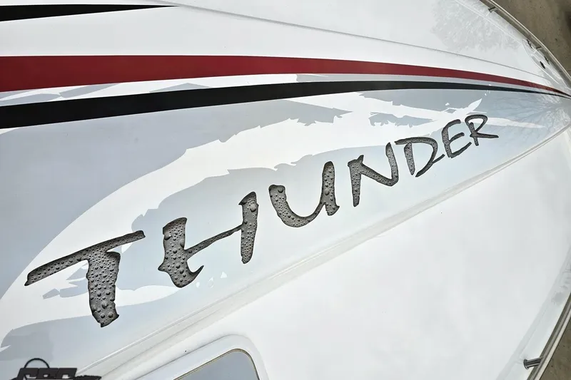 Slide: The Image of 2004 Black Thunder 460 boat with bold 'Thunder' graphic on sleek white hull. - 66
