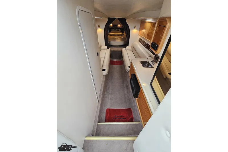 Slide: The Image of Interior of 2004 Black Thunder 460 boat, featuring seating, kitchenette, and modern amenities. - 70