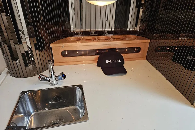 Slide: The Image of Kitchen area of 2004 Black Thunder 460 with sink and branded cap. - 76