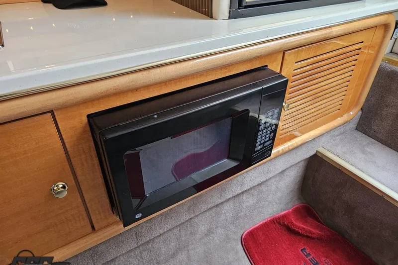 Slide: The Image of 2004 Black Thunder 460 interior with built-in microwave and wooden cabinetry. - 77