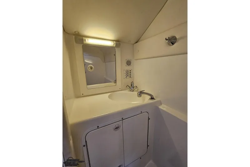 Slide: The Image of Compact bathroom in a 2004 Black Thunder 460 boat, featuring a sink and mirror. - 91