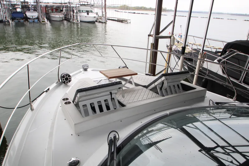 Slide: The Image of 2019 Cruisers Yachts 42 Cantius with sun loungers and table on deck, docked at marina. - 102