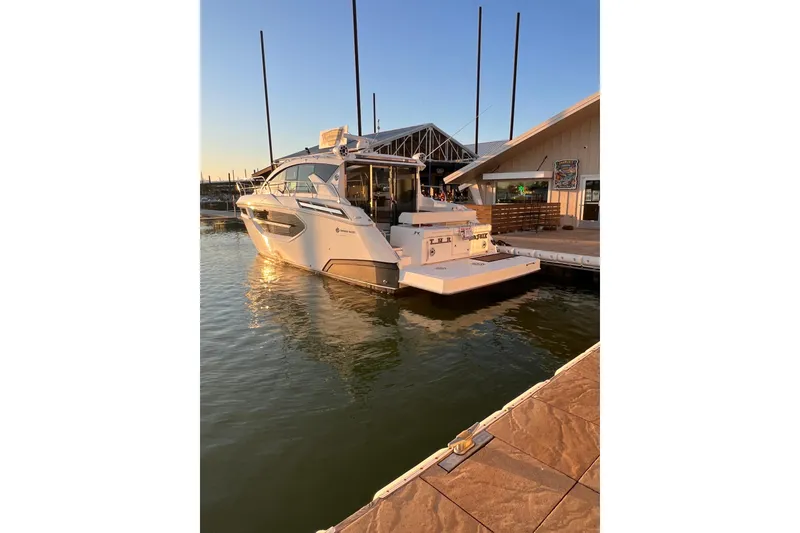 Slide: The Image of 2019 Cruisers Yachts 42 Cantius docked at sunset, reflecting on calm water. - 124