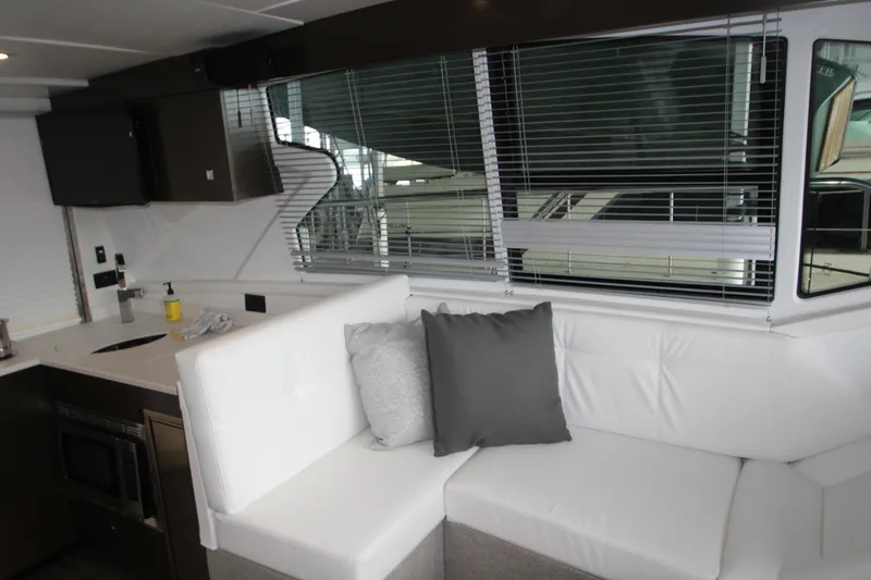 Slide: The Image of Interior of 2019 Cruisers Yachts 42 Cantius with white seating and modern kitchen area. - 59