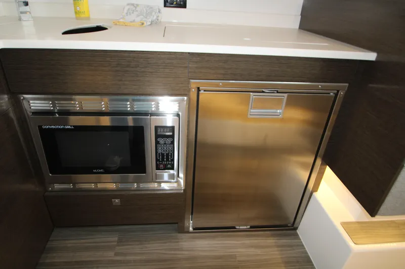 Slide: The Image of Modern kitchen area in 2019 Cruisers Yachts 42 Cantius with microwave and stainless steel fridge. - 77