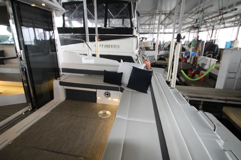 Slide: The Image of 2019 Cruisers Yachts 42 Cantius interior with seating and cushions in a marina setting. - 83