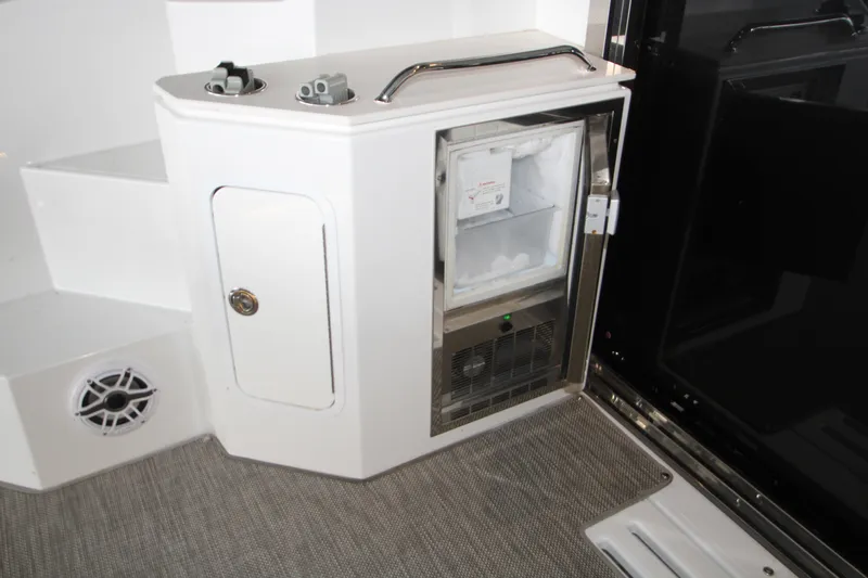 Slide: The Image of 2019 Cruisers Yachts 42 Cantius interior with open mini fridge and storage compartment. - 76