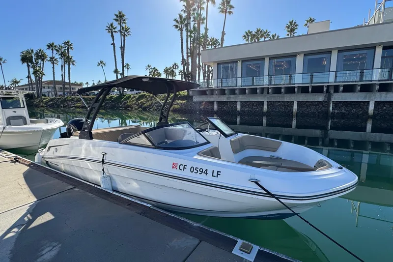 Slide: The Image of 2022 Bayliner VR6 Bowrider OB docked near waterfront building and palm trees. - 10