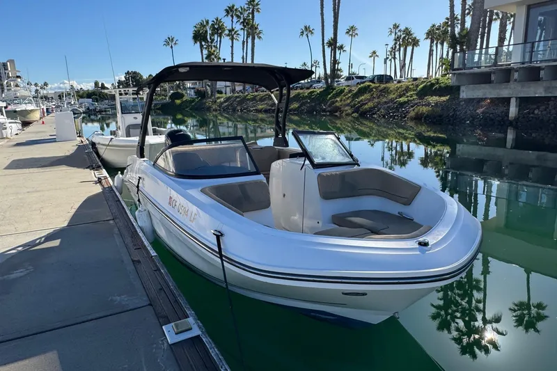 Slide: The Image of 2022 Bayliner VR6 Bowrider OB docked in a sunny marina with palm trees. - 11