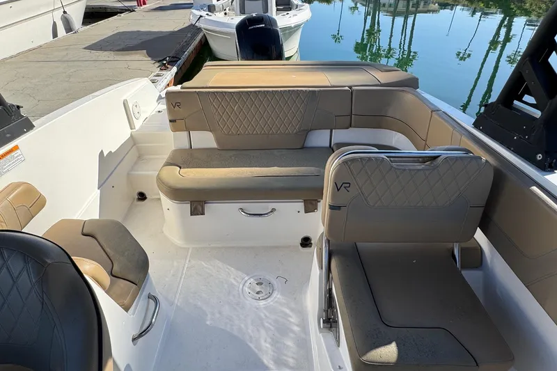 Slide: The Image of 2022 Bayliner VR6 Bowrider OB storage compartment with open hatch and cushioned seating. - 17