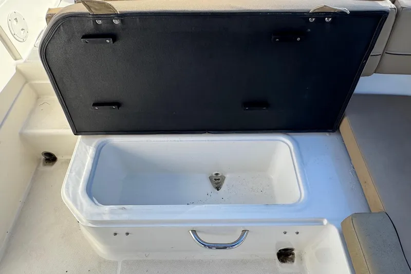 Slide: The Image of 2022 Bayliner VR6 Bowrider OB interior with tan seating and water reflection. - 22