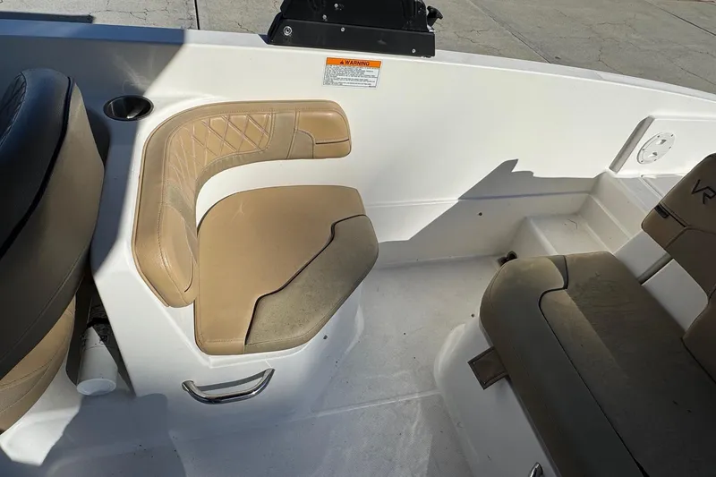 Slide: The Image of 2022 Bayliner VR6 Bowrider OB interior with tan seating, docked at marina. - 29