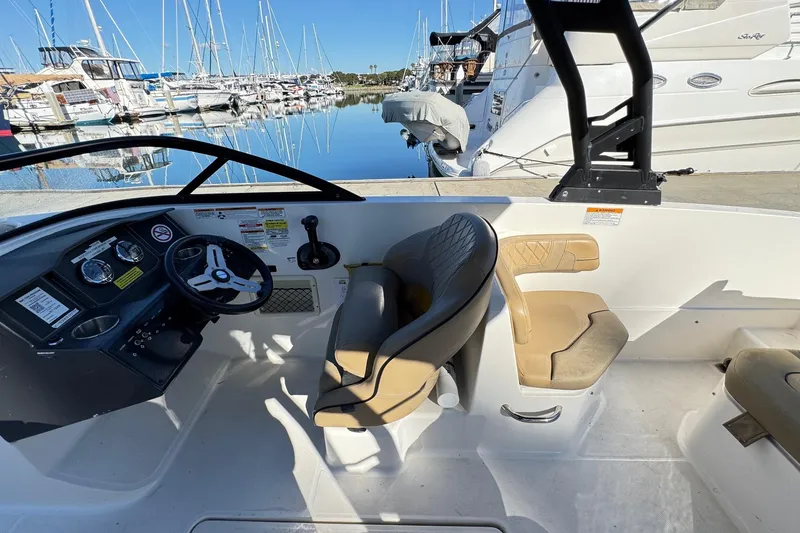 Slide: The Image of 2022 Bayliner VR6 Bowrider OB interior with dashboard and seating, docked at marina. - 30