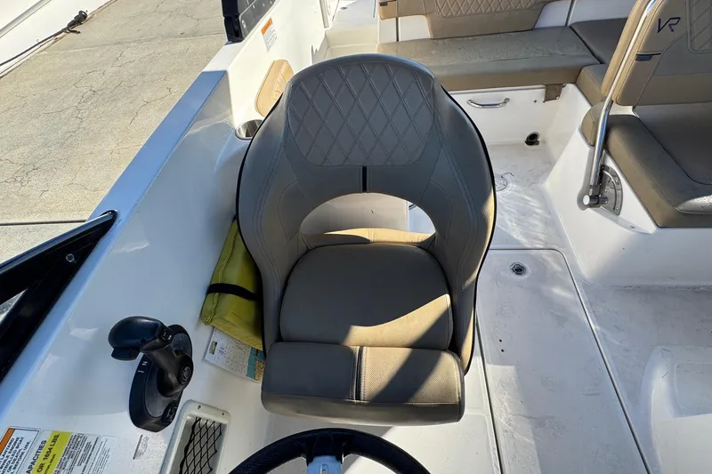 Slide: The Image of 2022 Bayliner VR6 Bowrider OB interior with steering wheel and beige seating. - 32