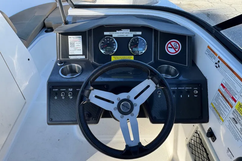 Slide: The Image of 2022 Bayliner VR6 Bowrider OB interior with tan seating and steering wheel. - 34