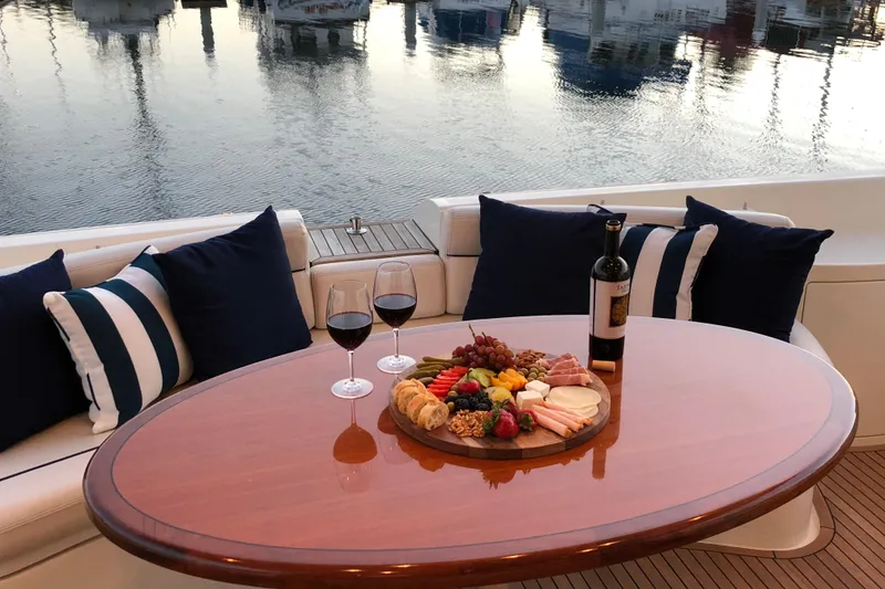 Slide: The Image of Luxurious 2007 Azimut 62 Evolution yacht with elegant dining setup, wine, and charcuterie board. - 12