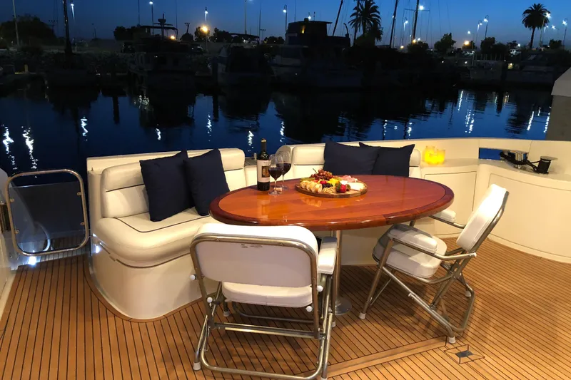 Slide: The Image of Luxurious 2007 Azimut 62 Evolution yacht deck with elegant dining setup at sunset. - 18