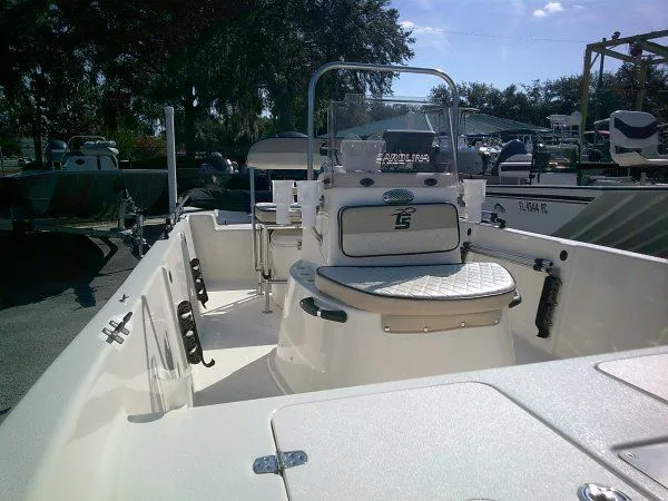 Slide: The Image of 2022 Carolina Skiff JLS 178 boat interior with seating and console, parked outdoors. - 6