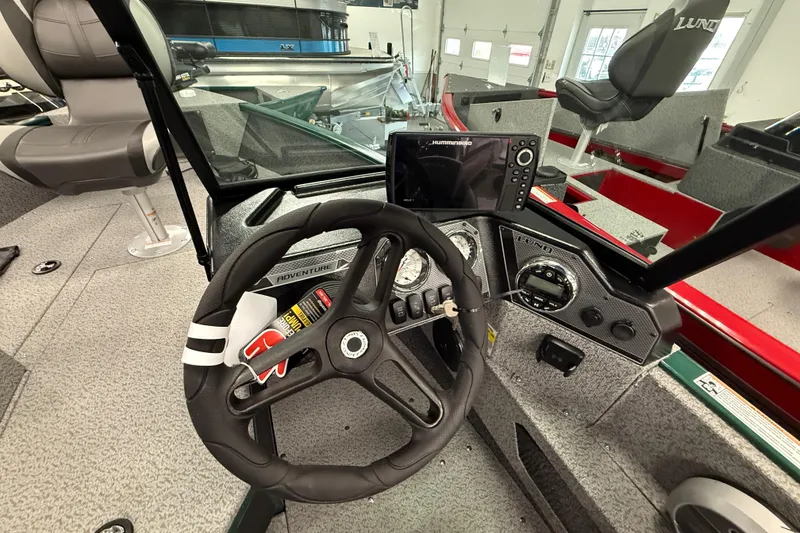 Slide: The Image of 2026 Lund 1775 Adventure Sport boat interior with steering wheel and navigation system. - 8