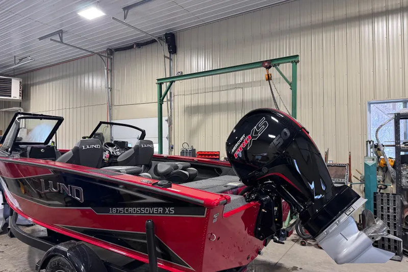Slide: The Image of 2026 Lund Crossover XS 1875 boat in workshop, rear view with motor and propeller. - 10