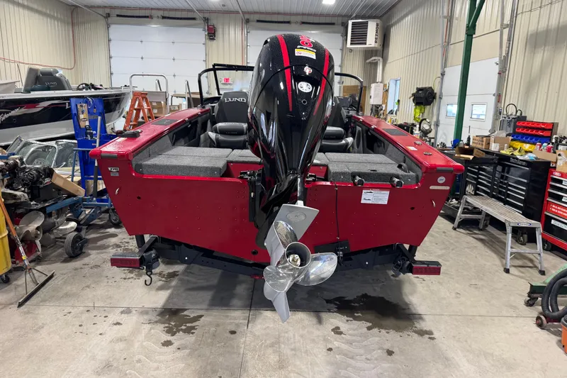 Slide: The Image of Red 2026 Lund Crossover XS 1875 boat in a workshop. - 11