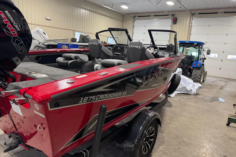 Slide: The Image of 2026 Lund Crossover XS 1875 boat in a garage, showcasing interior and windshield. - 12