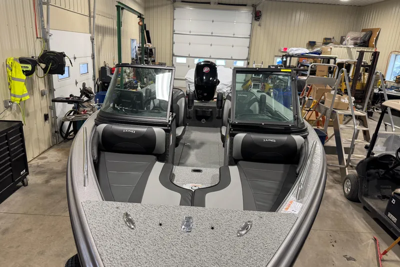 Slide: The Image of 2026 Lund Crossover XS 1875 boat in a garage, featuring a sleek red design. - 13