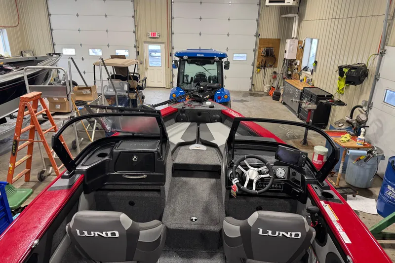 Slide: The Image of 2026 Lund Crossover XS 1875 boat interior with steering wheel and navigation system. - 4
