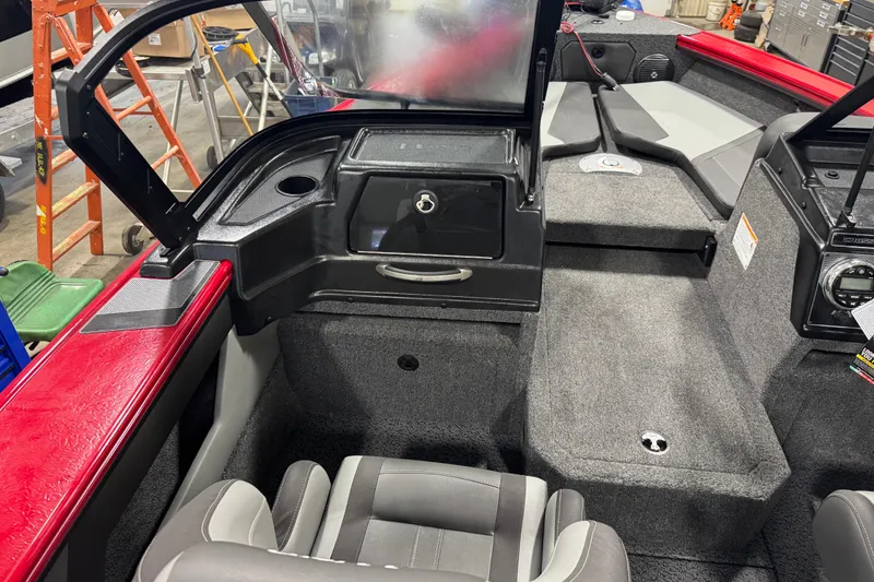 Slide: The Image of 2026 Lund Crossover XS 1875 boat interior with seating and motor in a garage setting. - 7