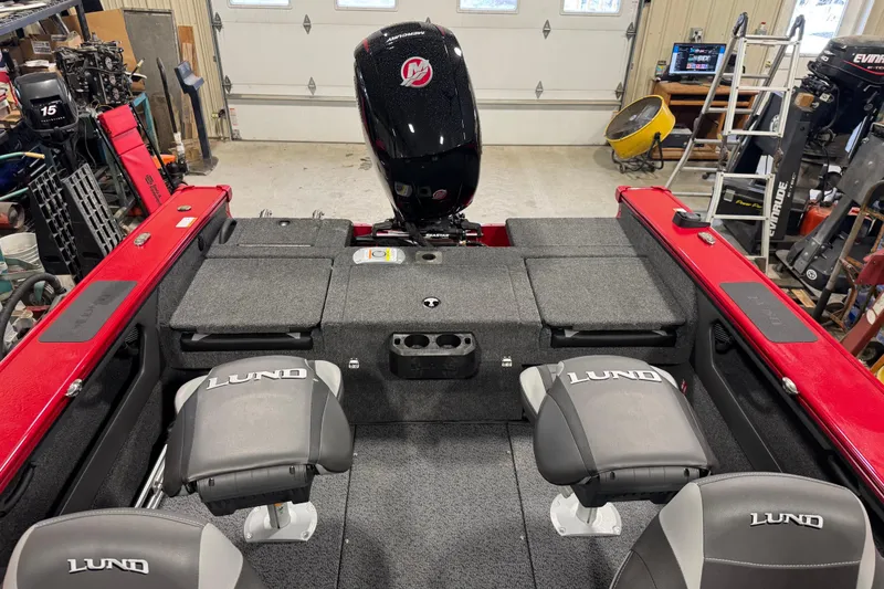 Slide: The Image of Red 2026 Lund Crossover XS 1875 boat in a garage setting. - 8