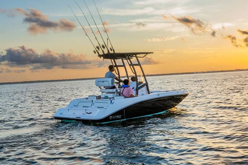Slide: The Image of 2023 Yamaha Boats 190 FSH Sport cruising at sunset on open water. - 5