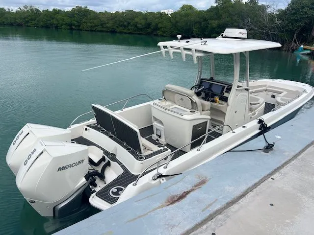 Slide: The Image of 2022 Boston Whaler DAUNTLESS boat docked, featuring dual Mercury engines, in a serene water setting. - 5