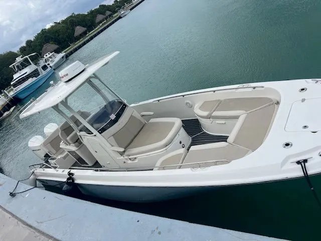 Slide: The Image of 2022 Boston Whaler DAUNTLESS boat docked in a marina, featuring sleek design and spacious seating. - 6