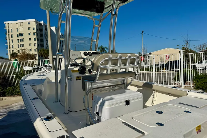 Slide: The Image of 2023 Key West 210 Bay Reef boat with T-top and console, parked near buildings. - 11