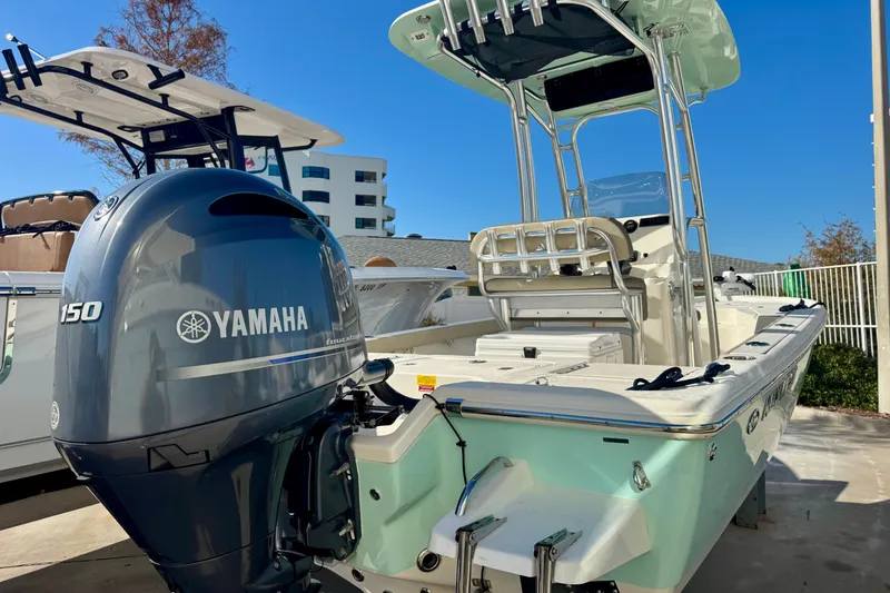 Slide: The Image of 2023 Key West 210 Bay Reef boat with Yamaha 150 engine, docked outdoors. - 14