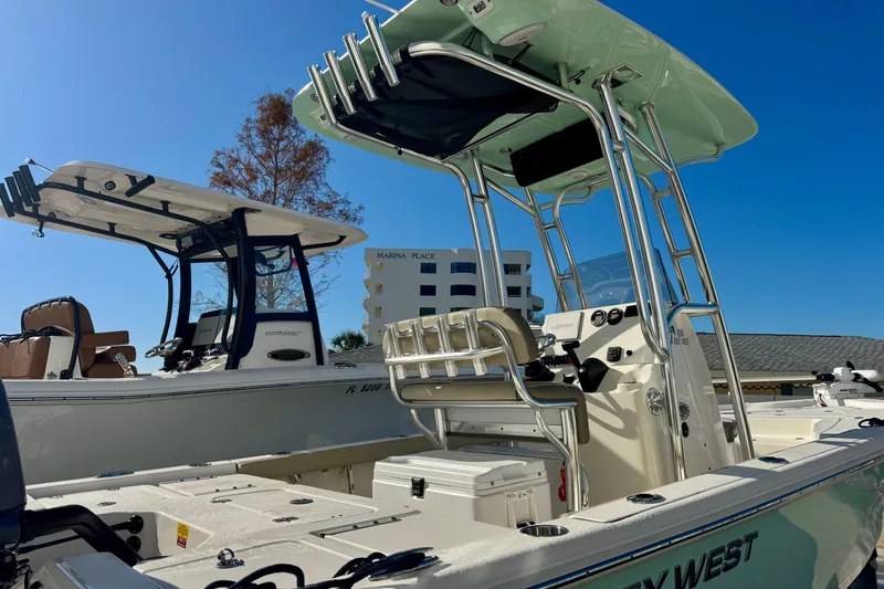 Slide: The Image of 2023 Key West 210 Bay Reef boat with T-top and console, docked under clear blue sky. - 15