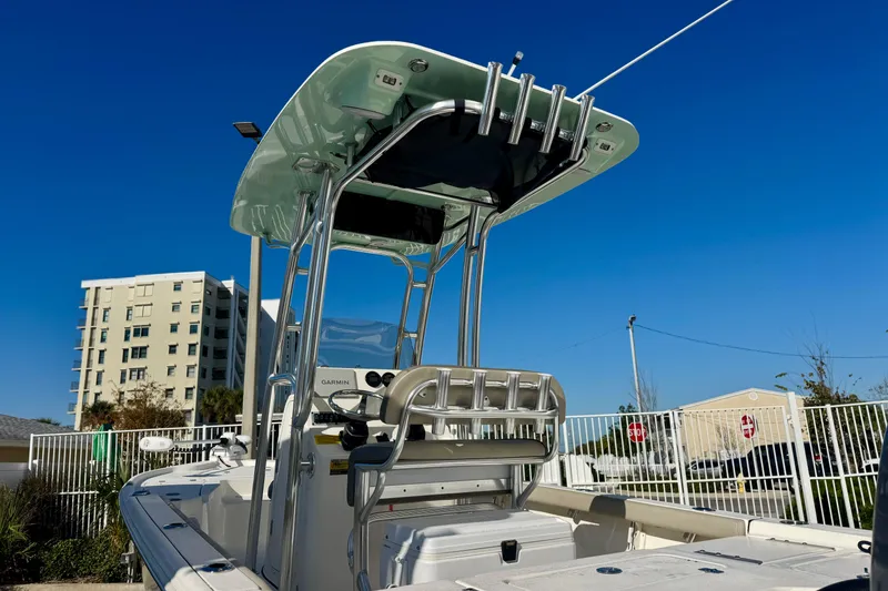 Slide: The Image of 2023 Key West 210 Bay Reef boat with T-top and seating, under clear blue sky. - 19