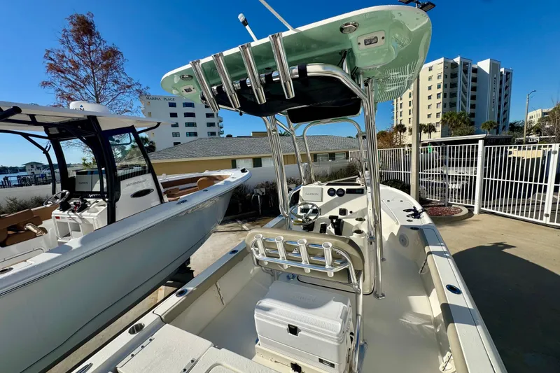 Slide: The Image of 2023 Key West 210 Bay Reef boat with T-top, docked near modern buildings. - 20