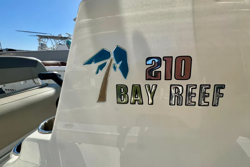 Slide: The Image of 2023 Key West 210 Bay Reef boat logo with palm tree design. - 43