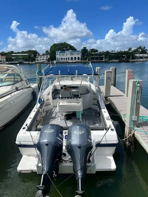 Slide: The Image of Intrepid 339 WALKAROUND boat docked, twin engines, clear sky, waterfront view. - 1