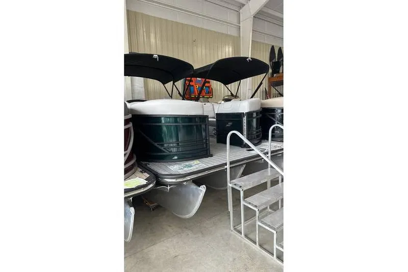 The Image of 2024 Starcraft SLS 3 pontoon boats displayed indoors with black canopies. - 0