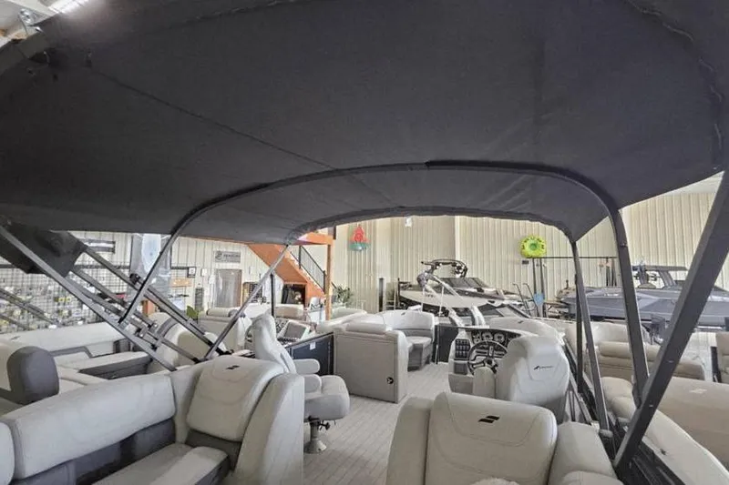 Slide: The Image of 2024 Starcraft SLS 3 pontoon boat interior with canopy, showcasing seating and helm. - 4