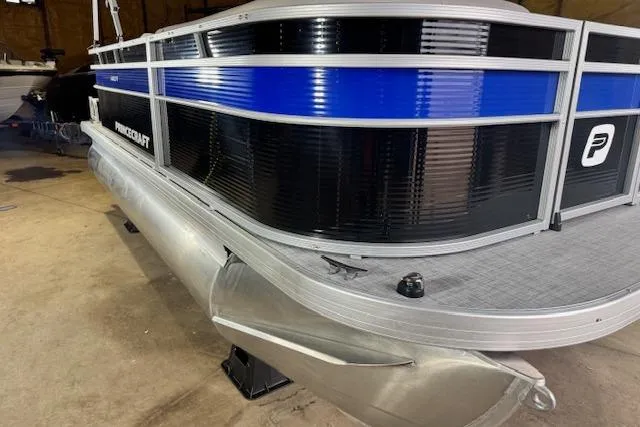 Slide: The Image of 2026 Princecraft Jazz 170 pontoon boat with sleek black and blue design in a garage setting. - 4