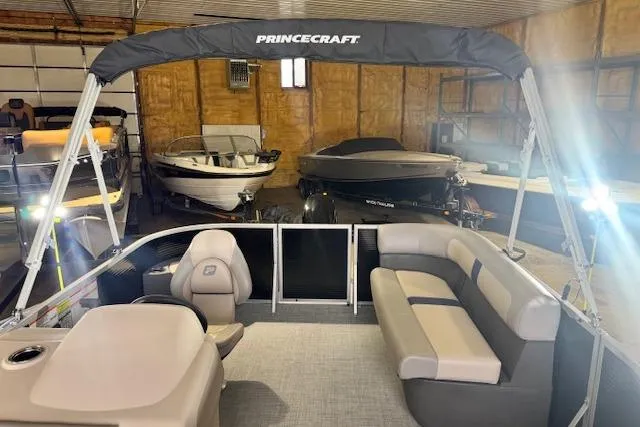 Slide: The Image of 2026 Princecraft Jazz 170 pontoon boat in a garage with other boats. - 6