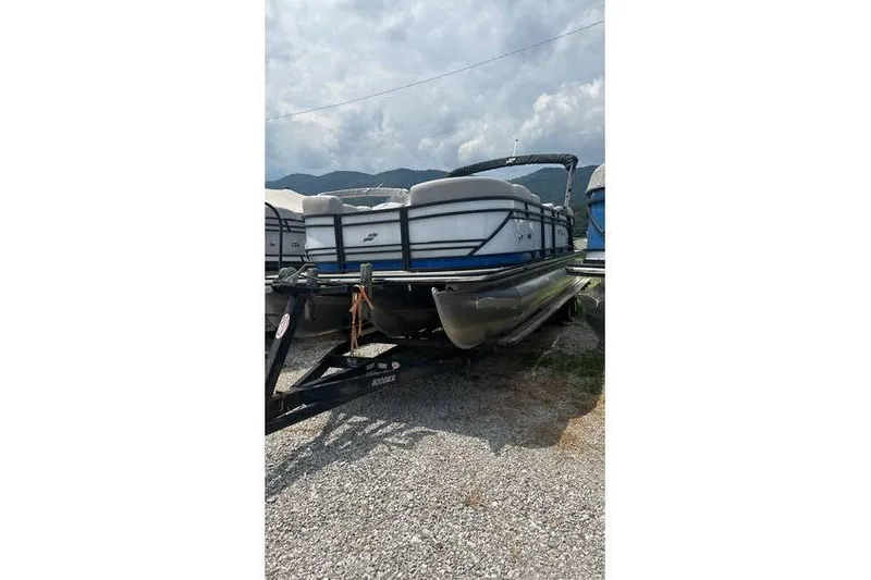 Slide: The Image of 2024 Starcraft SLS 3 pontoon boat on trailer, parked outdoors. - 4