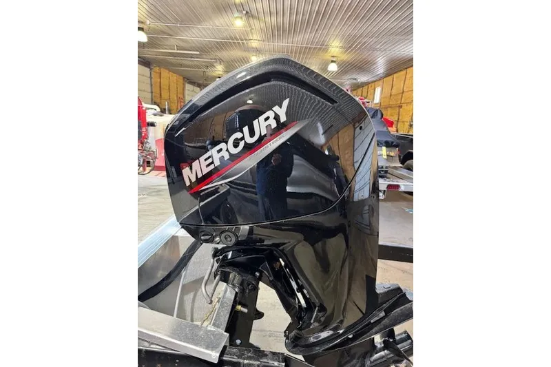 Slide: The Image of Mercury outboard motor on 2026 Princecraft Jazz 210-2S boat in a workshop setting. - 12