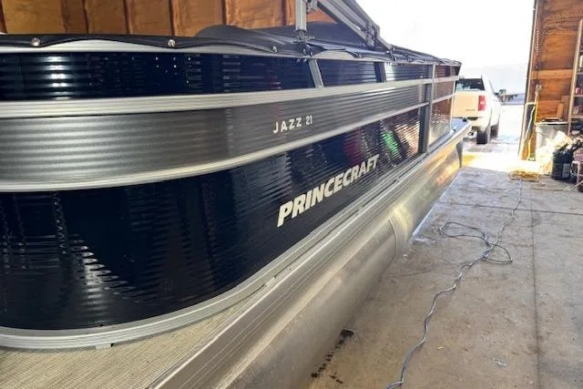 Slide: The Image of 2026 Princecraft Jazz 210-2S pontoon boat in a garage setting. - 3