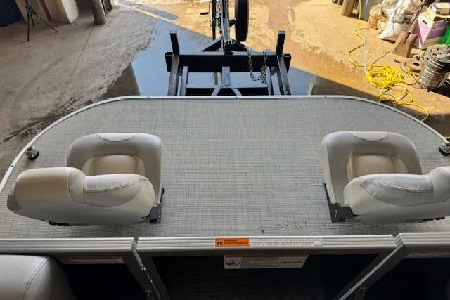 Slide: The Image of 2026 Princecraft Jazz 210-2S boat deck with two white seats, docked in a marina. - 6